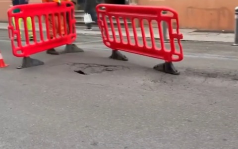 Voragine in strada nel cuore di Bologna: area transennata in via Nazario Sauro